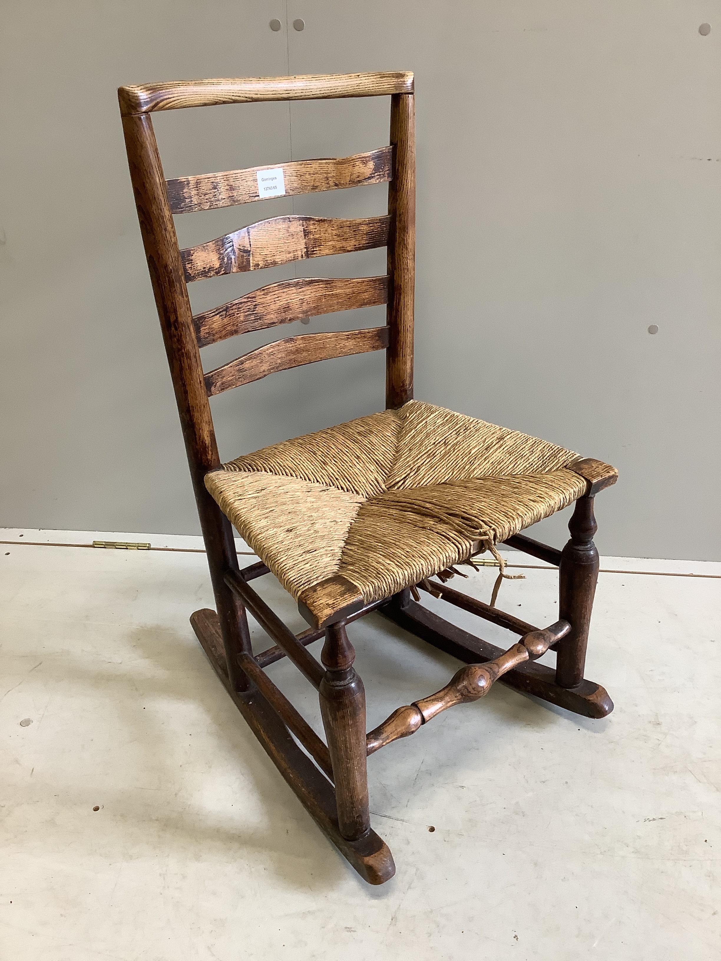 A 19th century ash rush seat ladderback rocking chair, width 48cm, depth 37cm, height 85cm
